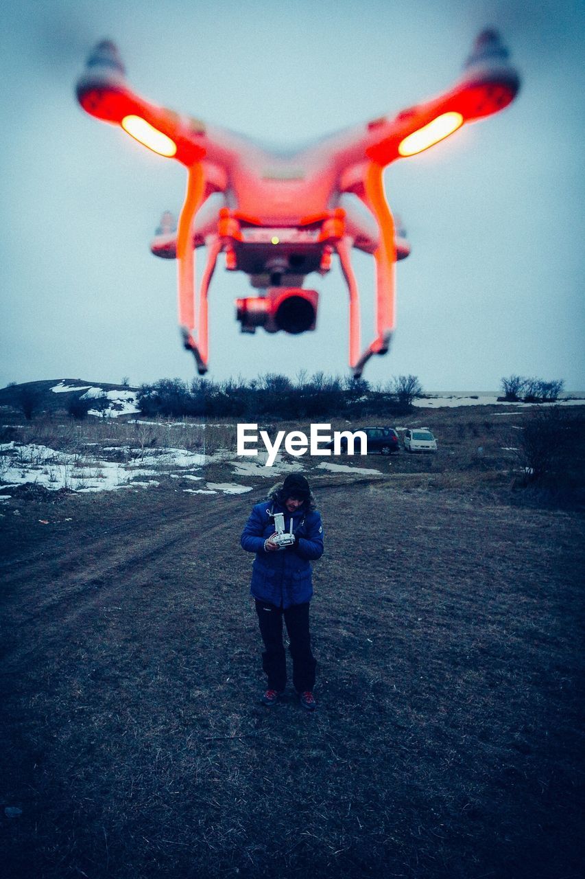 REAR VIEW OF WOMAN PHOTOGRAPHING AIRPLANE