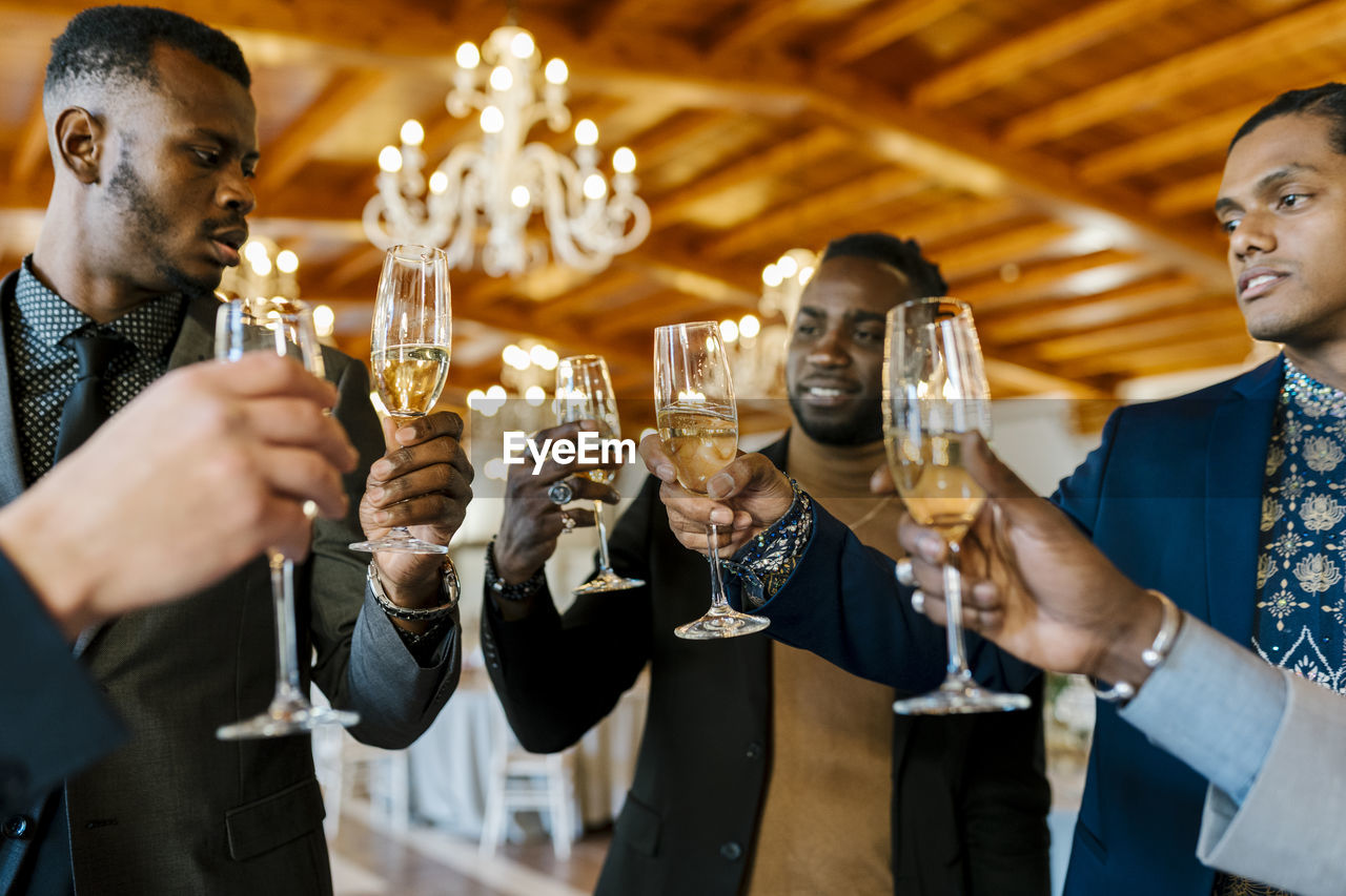 Male friends toasting champagne at banquet