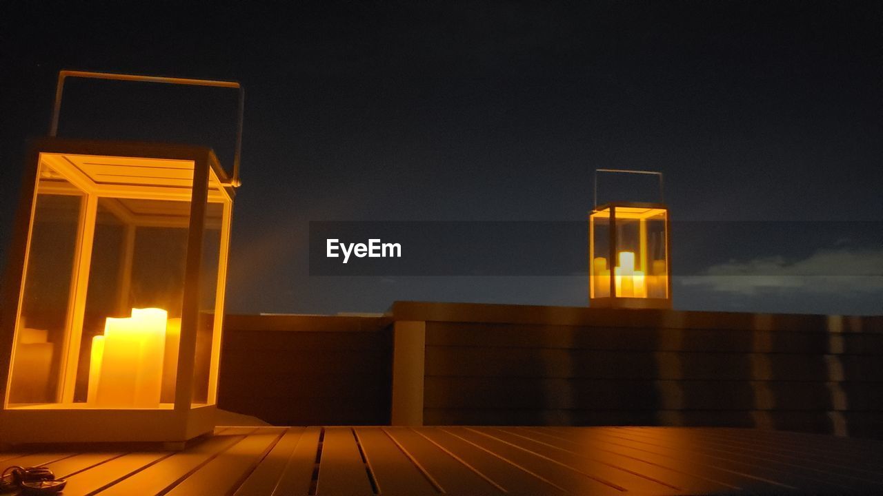 LOW ANGLE VIEW OF ILLUMINATED BUILDING AGAINST SKY DURING SUNSET