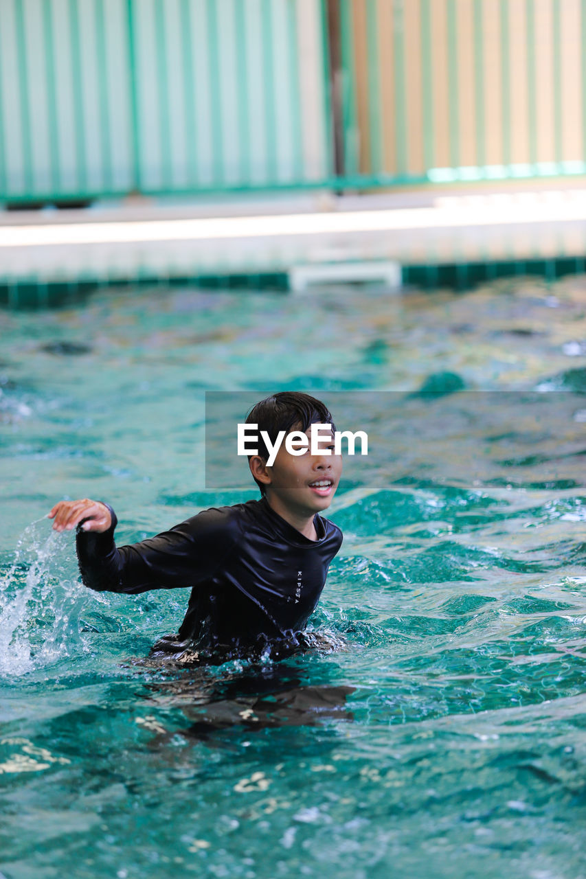 Portrait of young man swimming in pool