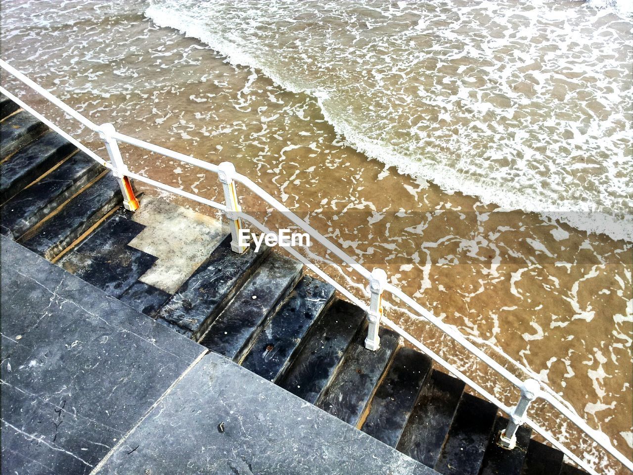 High angle view of staircase by sea at beach