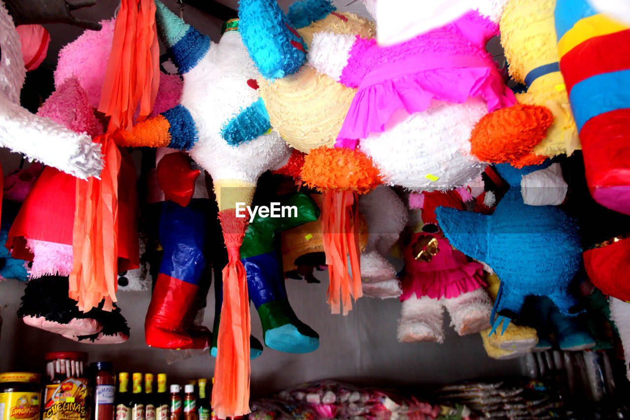 Low angle view of stuffed toys hanging at market stall