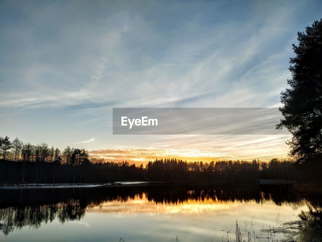 Scenic view of lake against sky at sunset