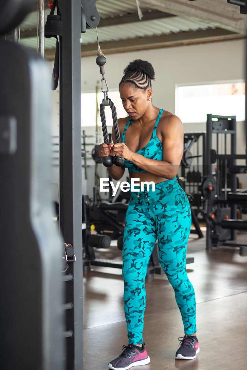 Sporty woman exercising pulley in studio. for arm and shoulder muscles. 