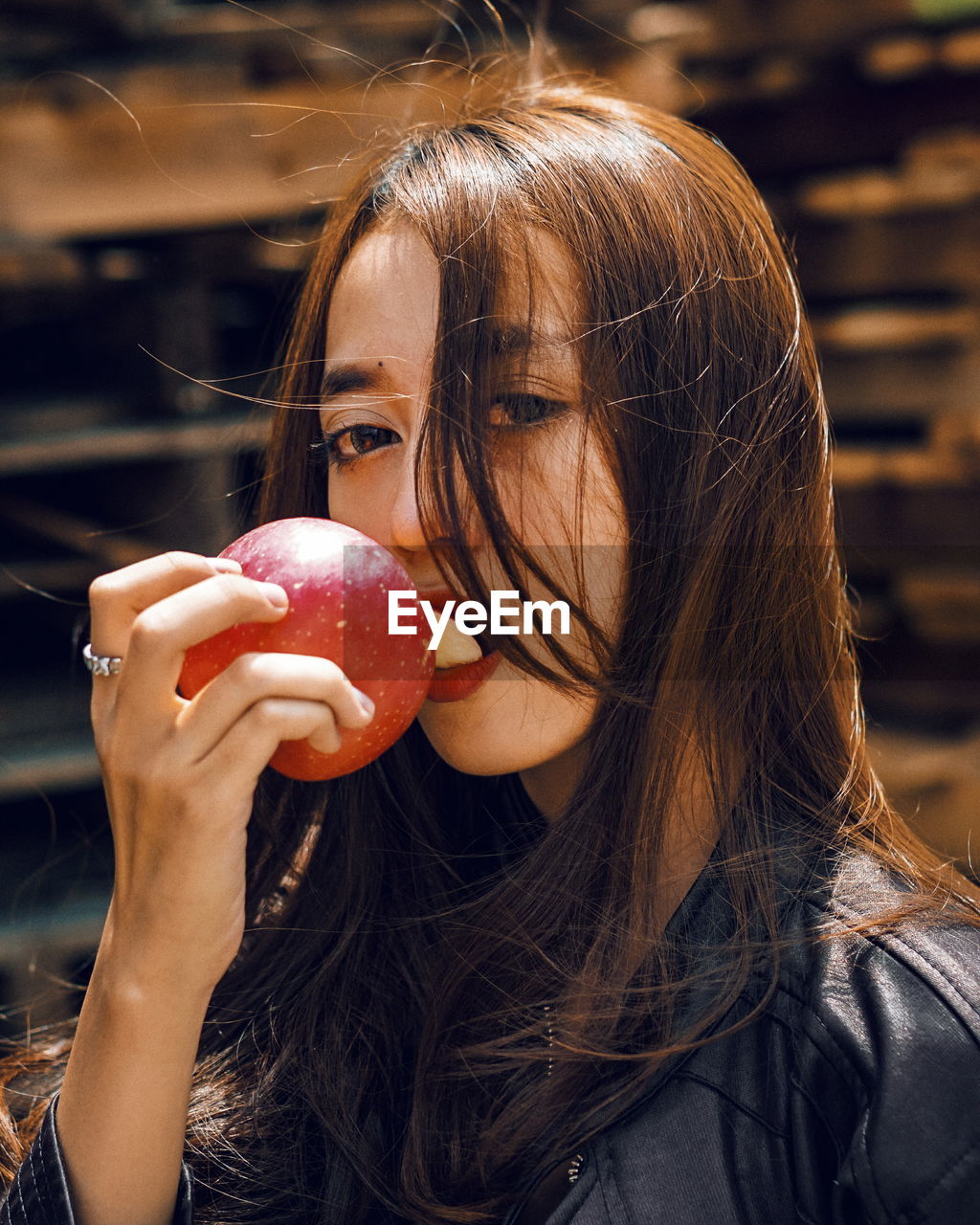 Close-up portrait of young woman eating apple