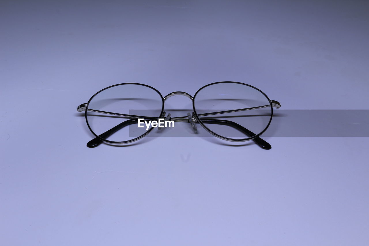 CLOSE-UP OF EYEGLASSES ON GLASS TABLE