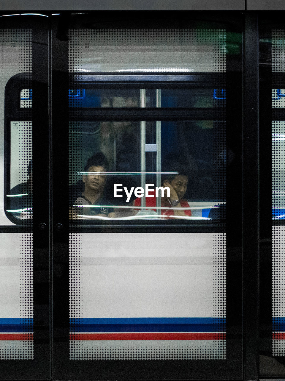 TRAIN IN RAILROAD STATION PLATFORM SEEN THROUGH WINDOW