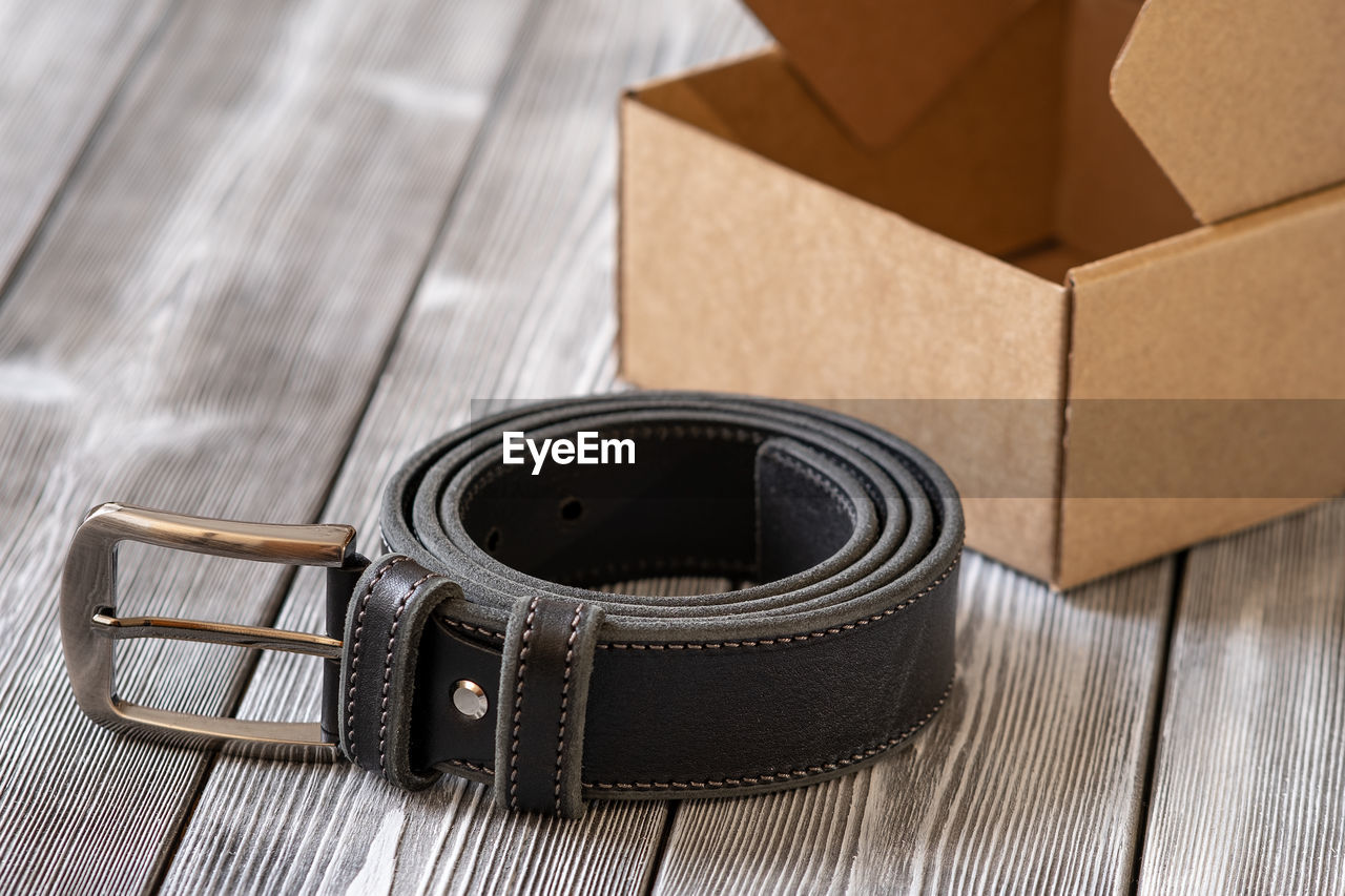 brown, box, container, cardboard, belt, no people, wood, indoors, paper, fashion accessory, strap, studio shot, high angle view, cardboard box, still life, packing, leather