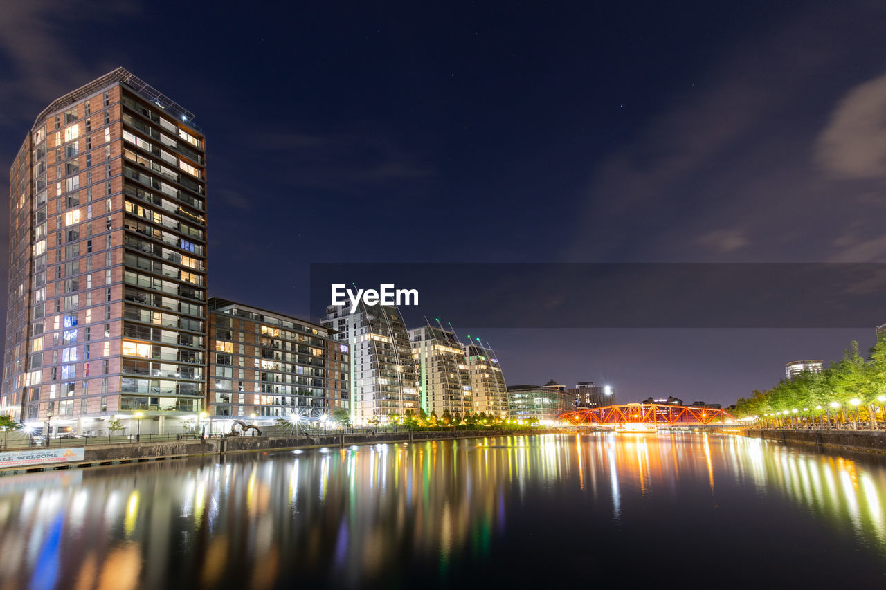 Long exposure night photo of buildings in city at waterfront