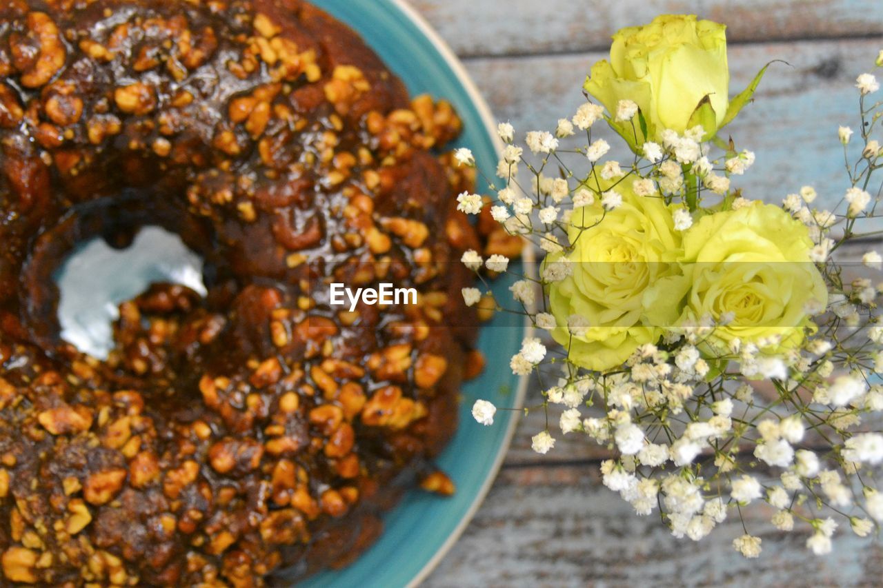 Close-up of flowers beside cake on table