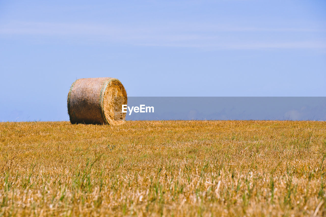 Hay bales on field against sky