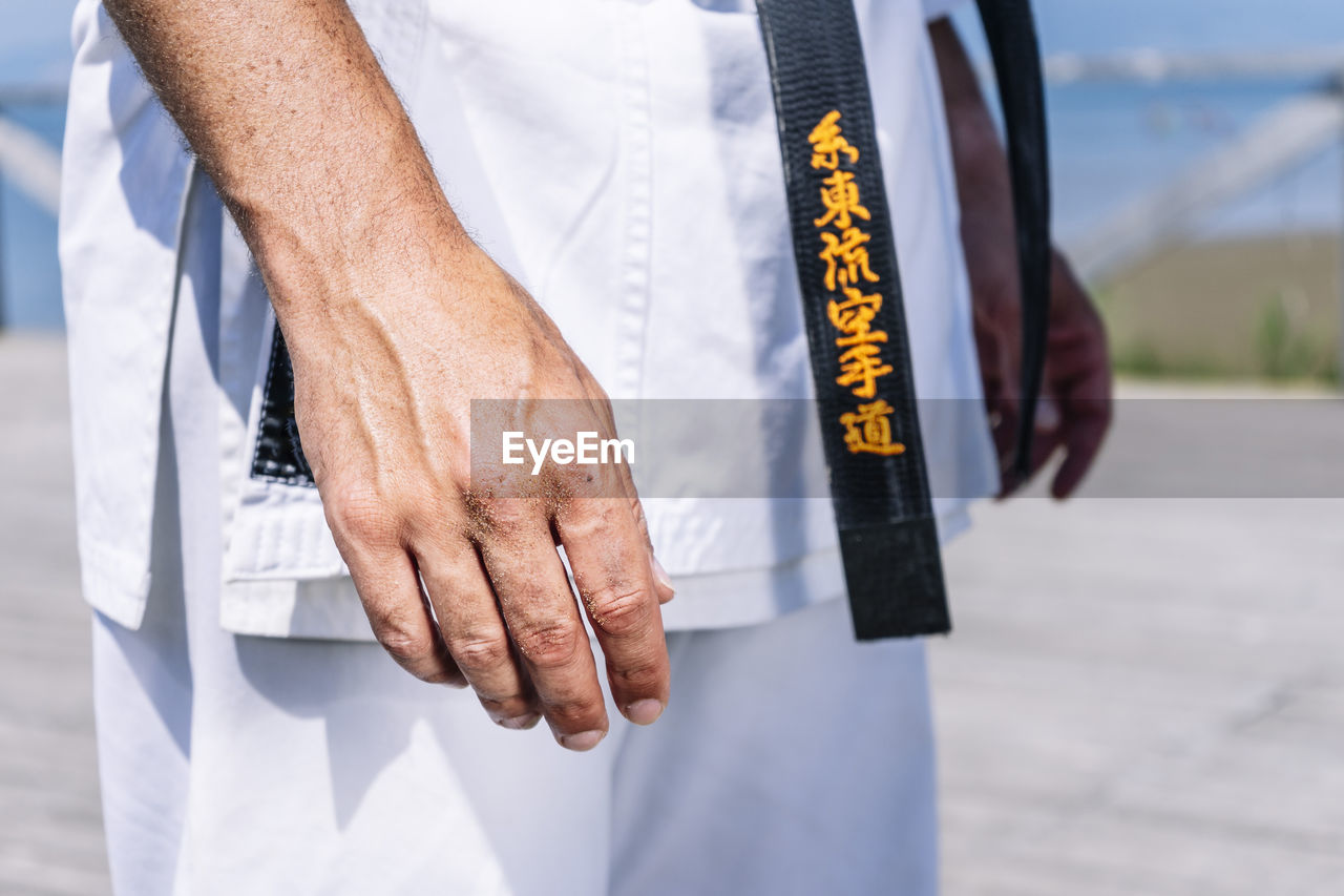 Karate expert with relaxed hands, close up image