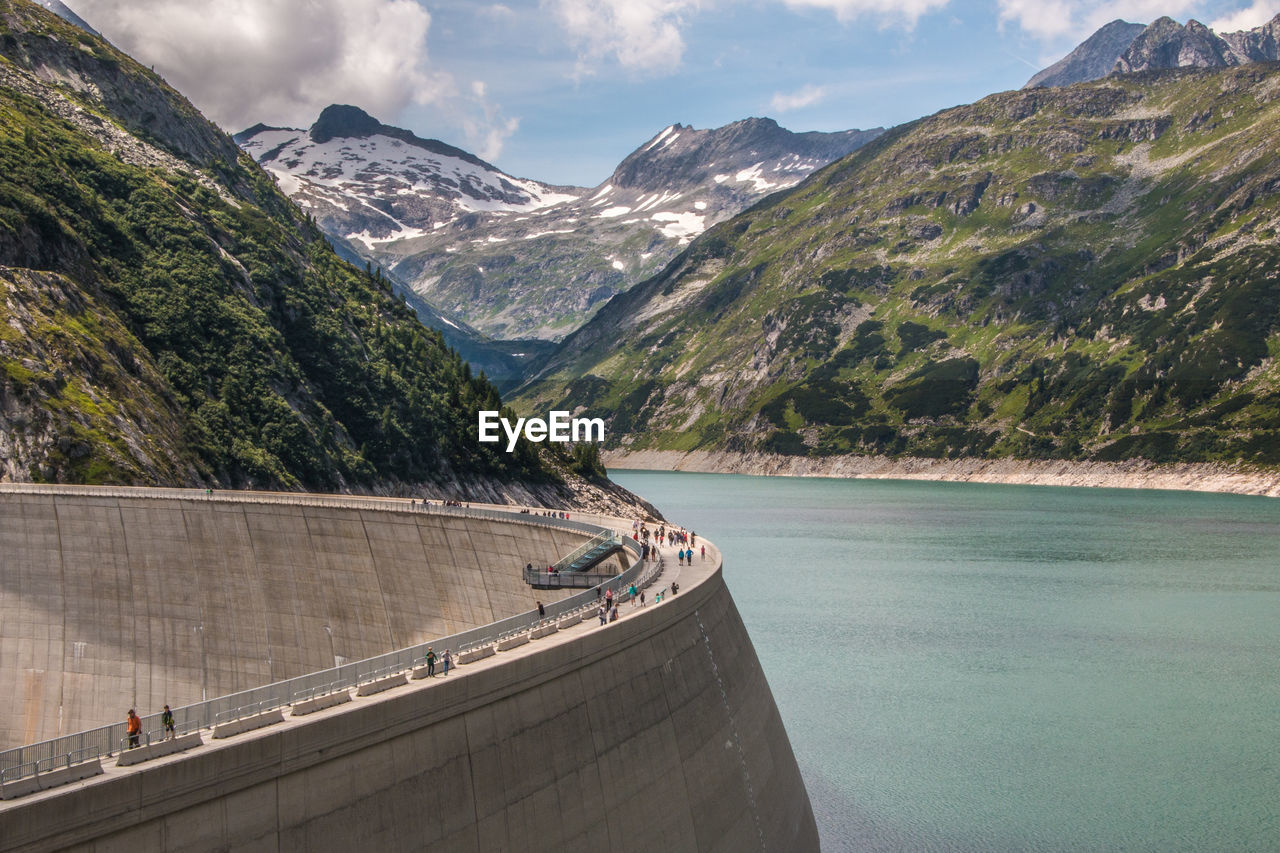 Scenic view of dam and mountains against sky