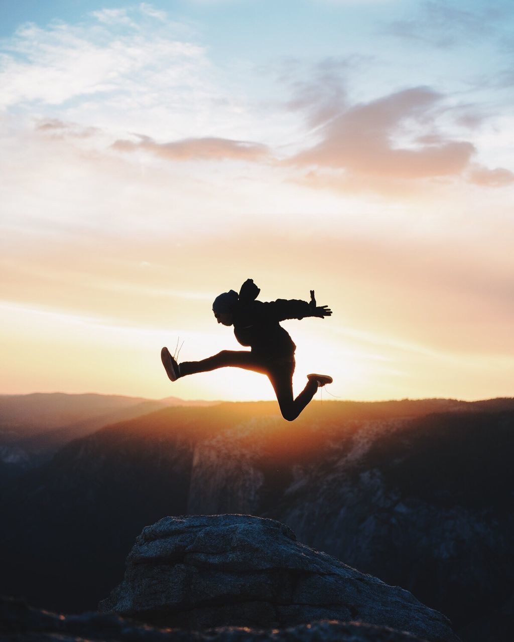 Silhouette of man jumping at sunset