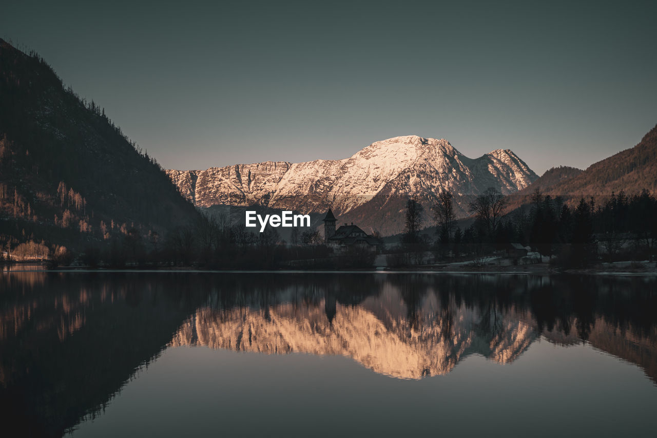 Scenic view of lake and mountains against sky during winter