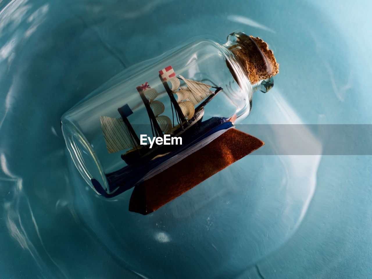 High angle view of ship in a bottle floating on blue water