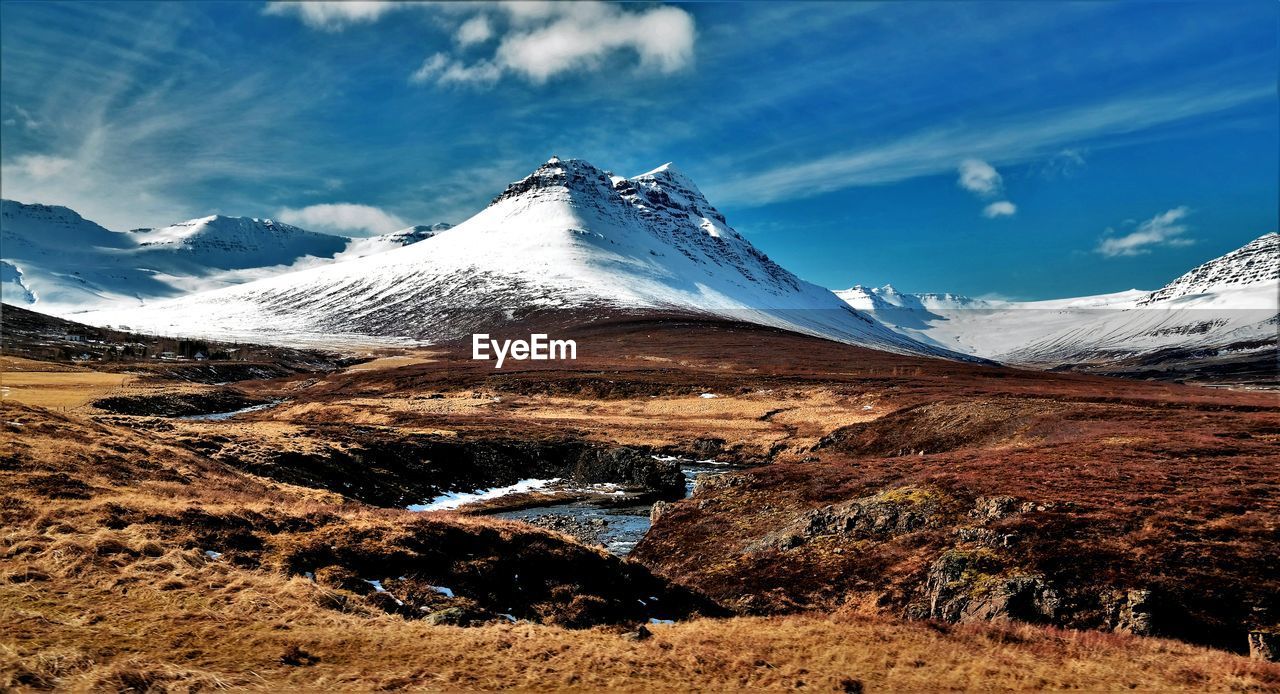 Scenic view of mountains against cloudy sky