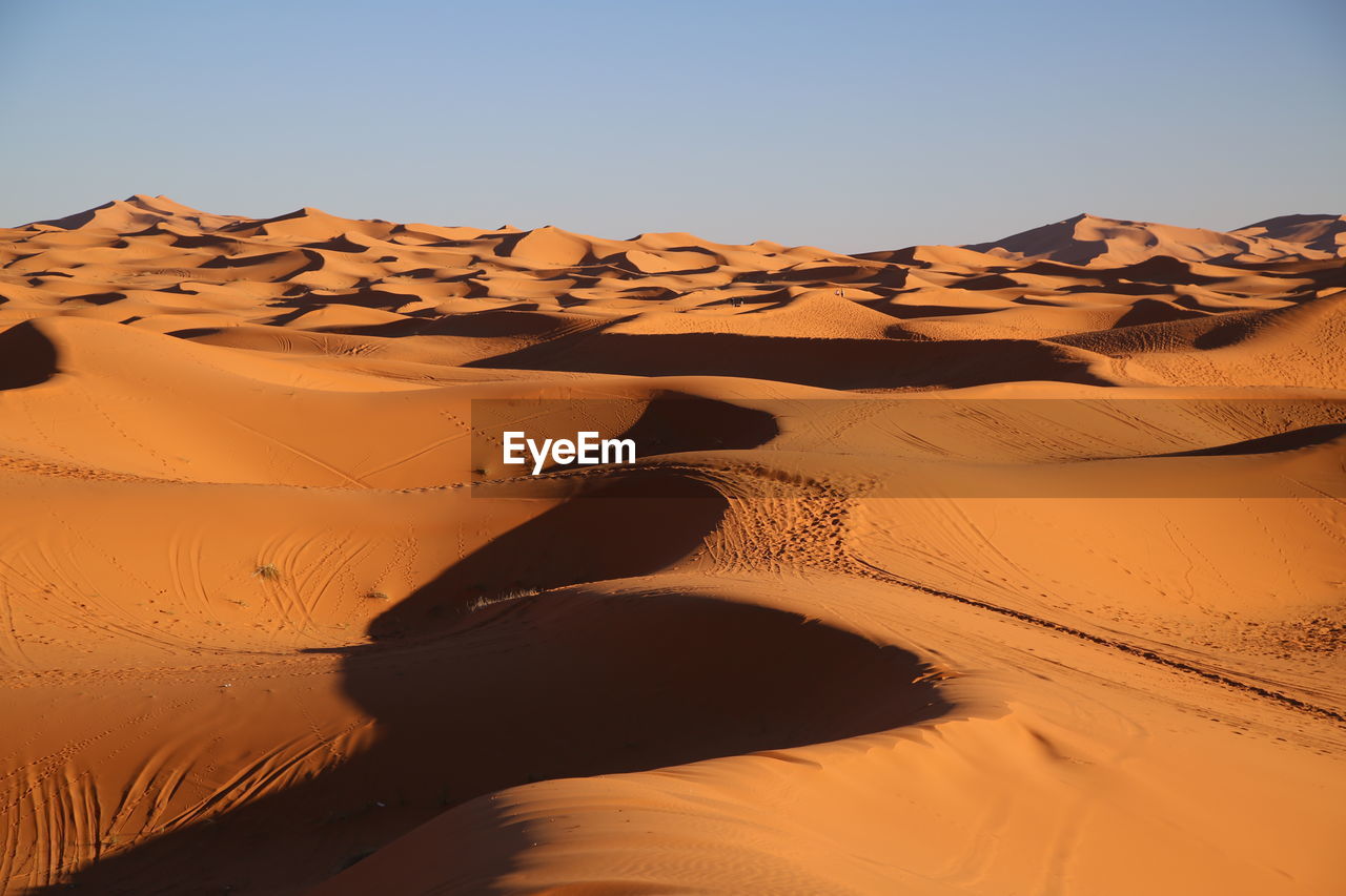 Sand dune in desert against clear sky