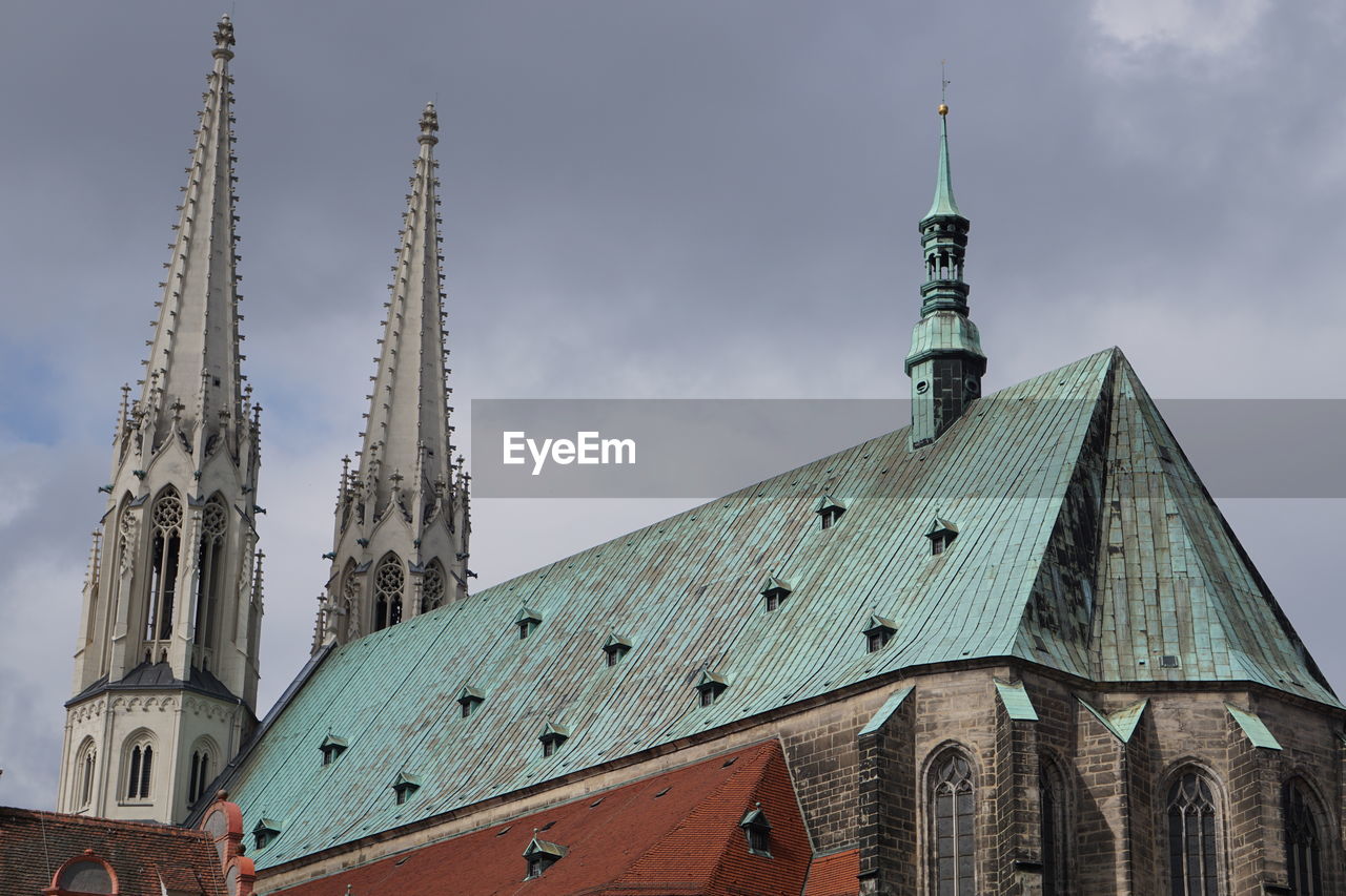 Low angle view of church against cloudy sky