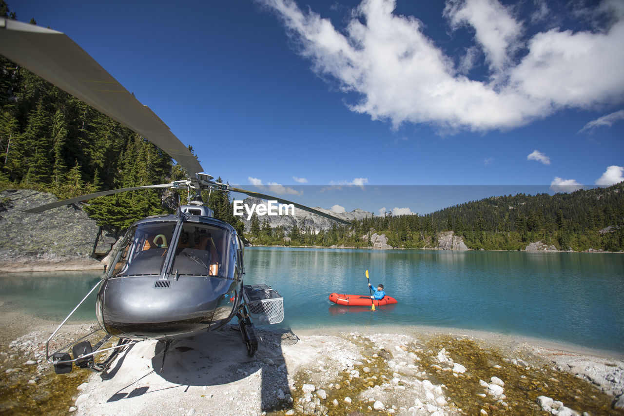 Active man paddling next to his helicopter.