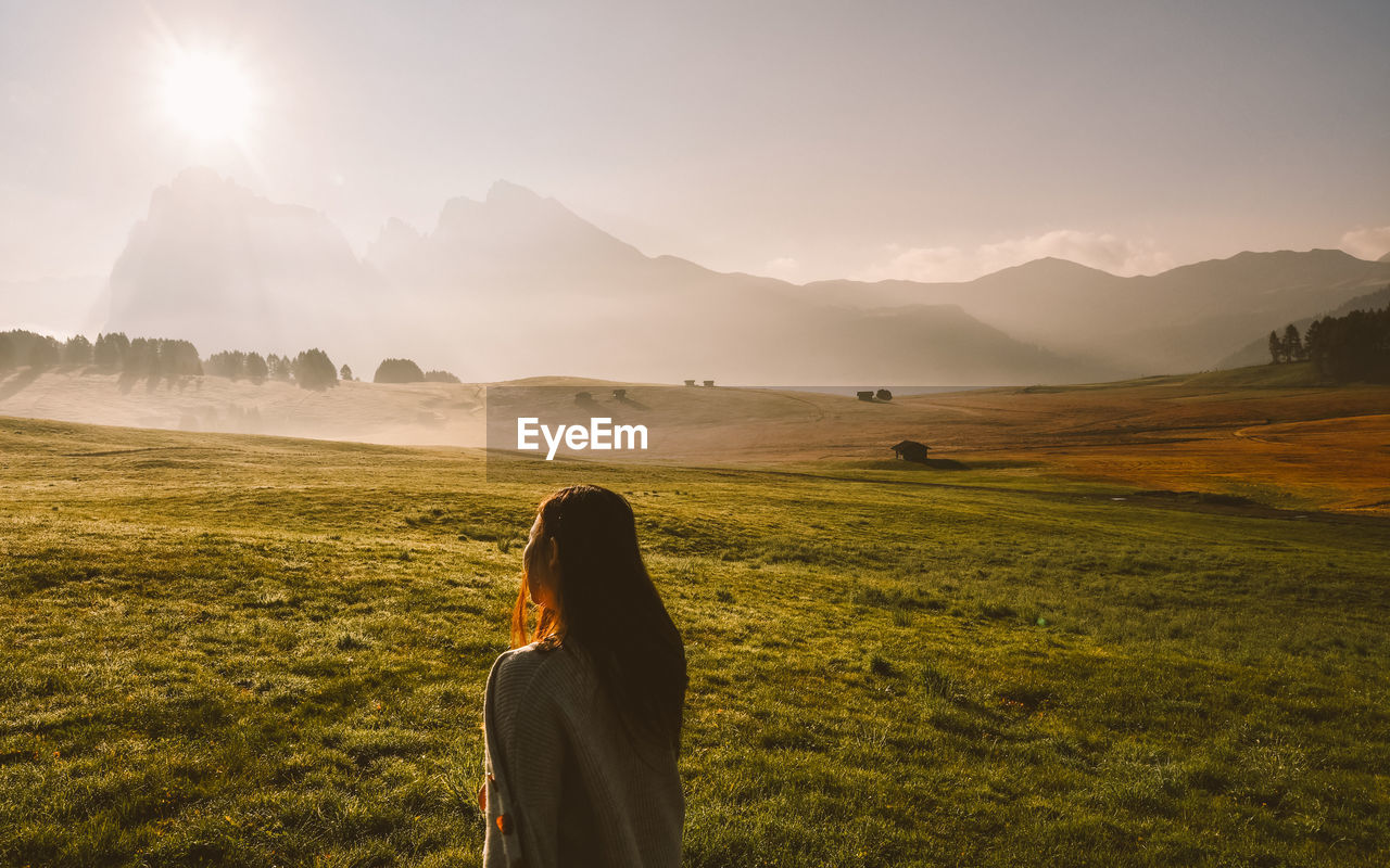 Woman standing on field against sky