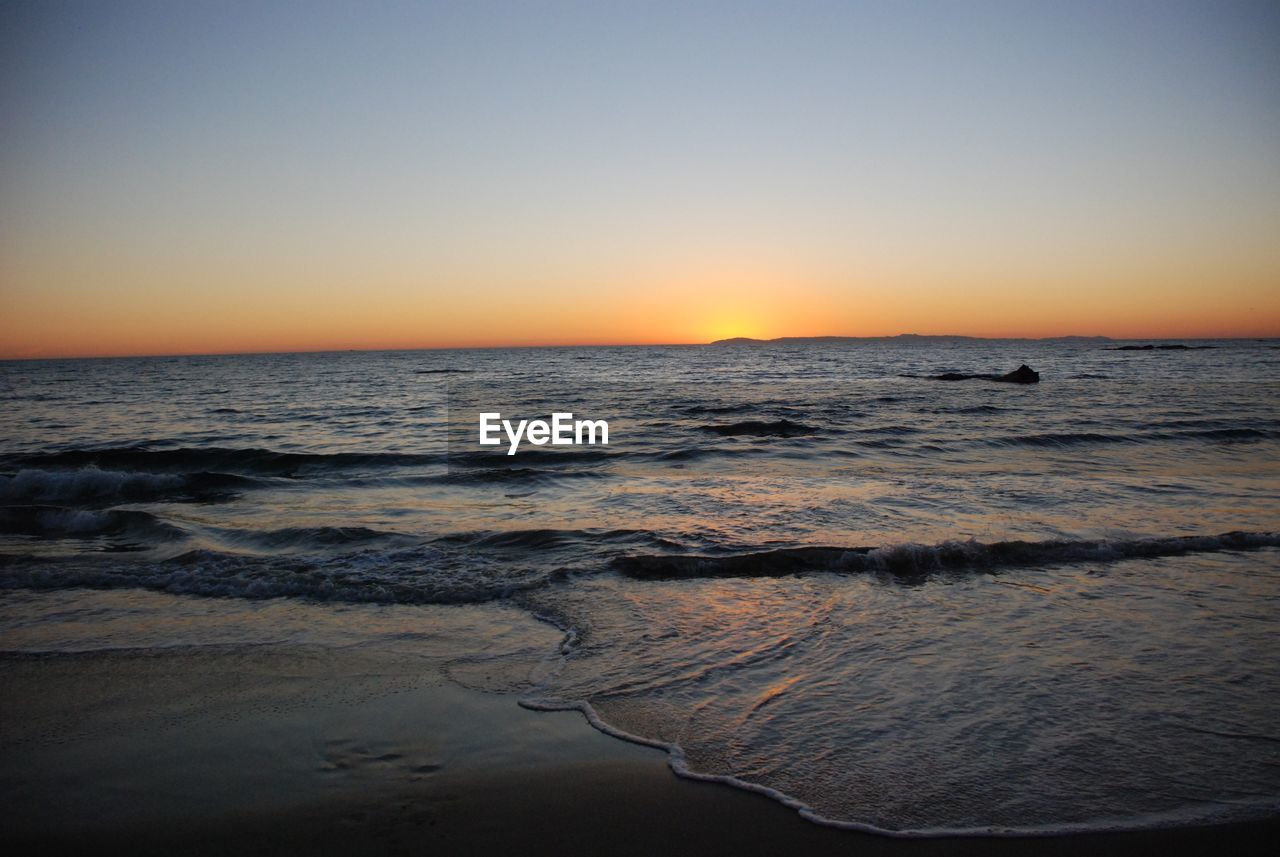 Scenic view of sea against clear sky during sunset