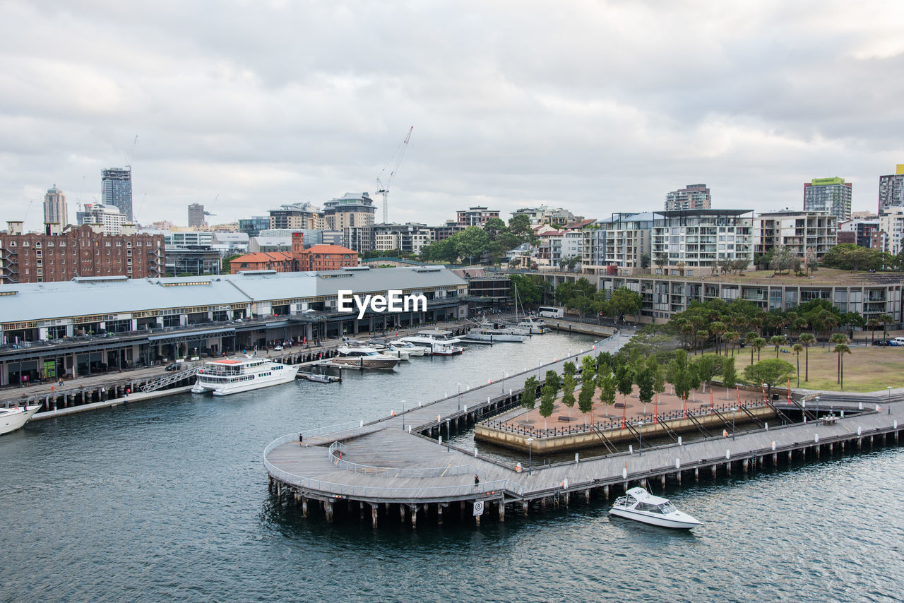 HIGH ANGLE VIEW OF RIVER AMIDST BUILDINGS AGAINST SKY