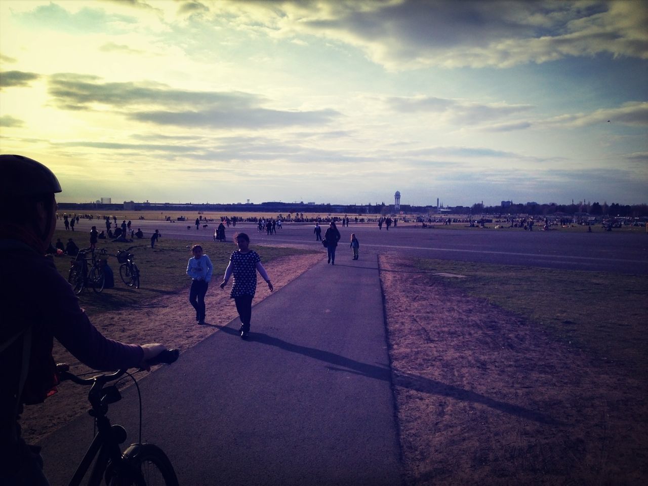 People walking on pathway along landscape