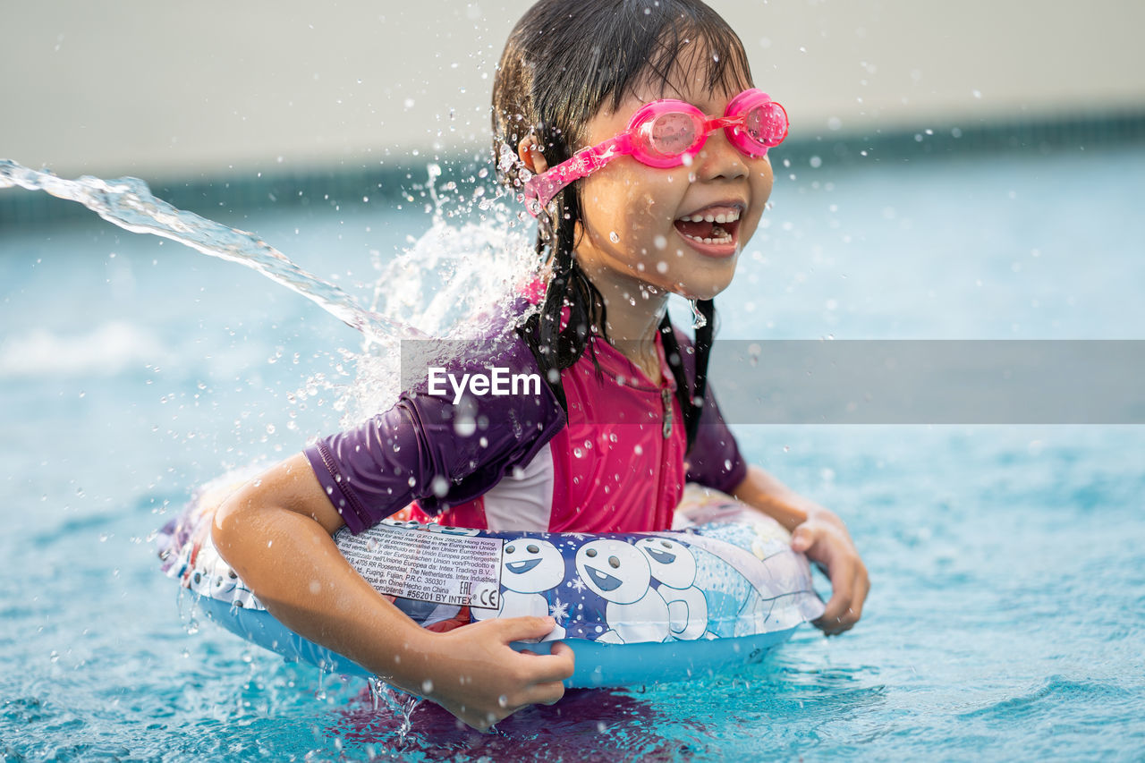 Happy girl enjoying in swimming pool