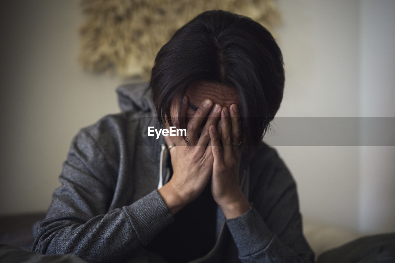 Man facing depression with hands covering his face