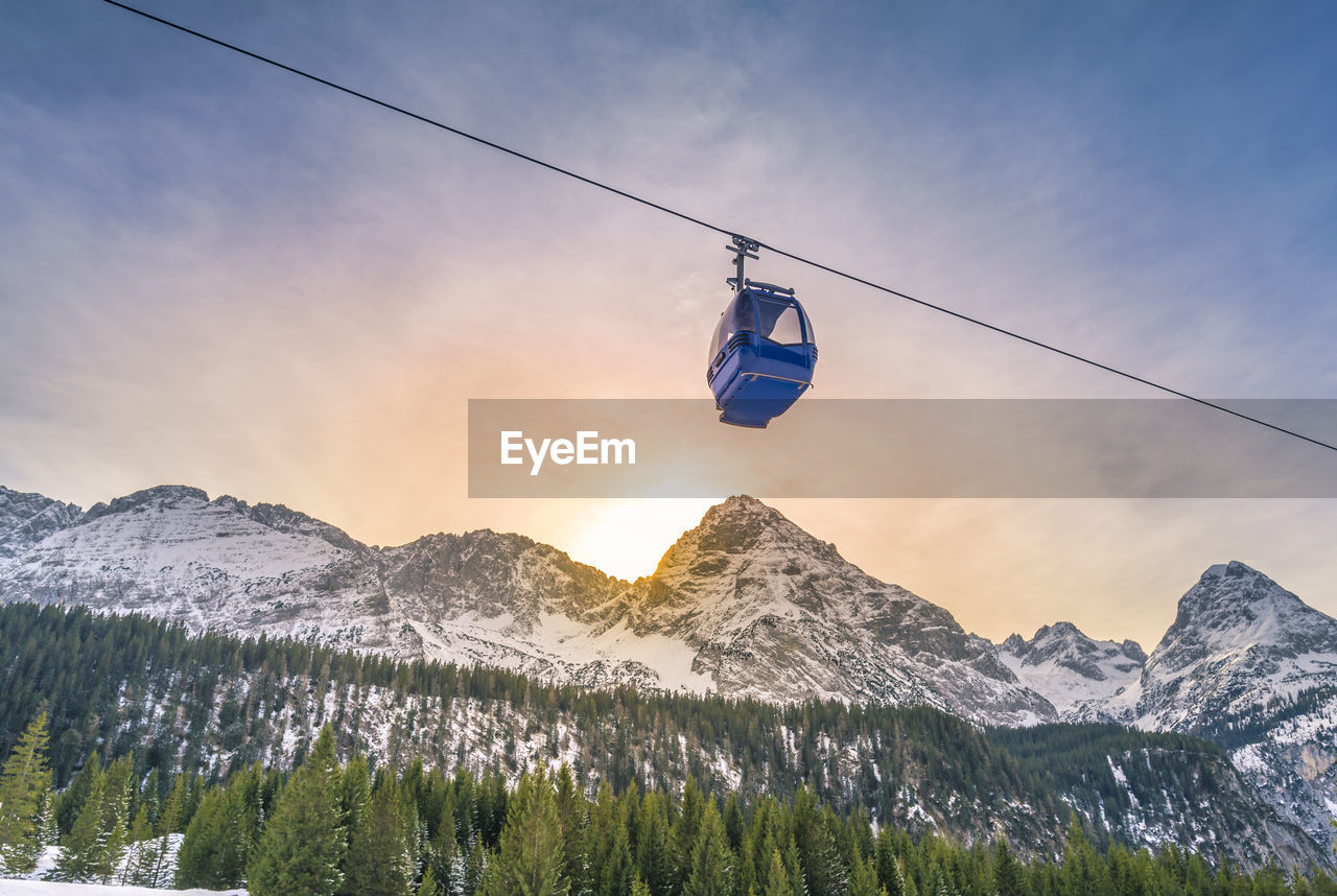 Low angle view of overhead cable car against sky