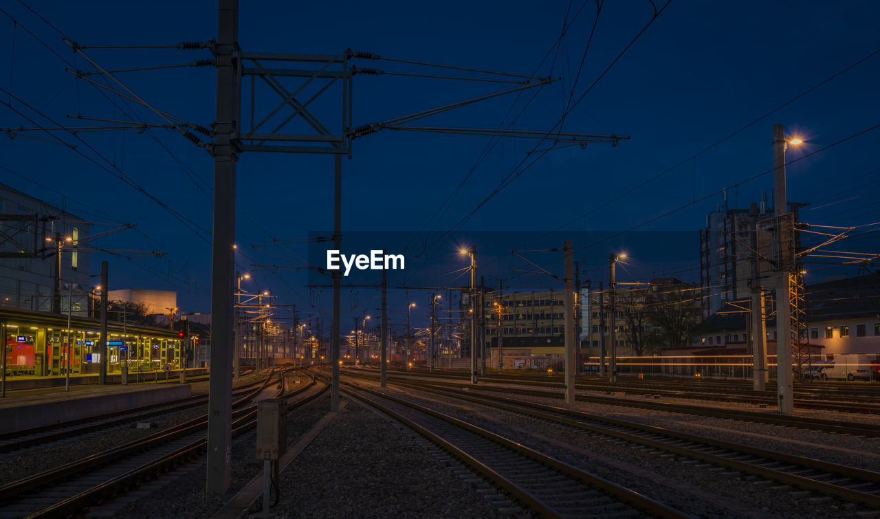 railroad tracks against sky at dusk