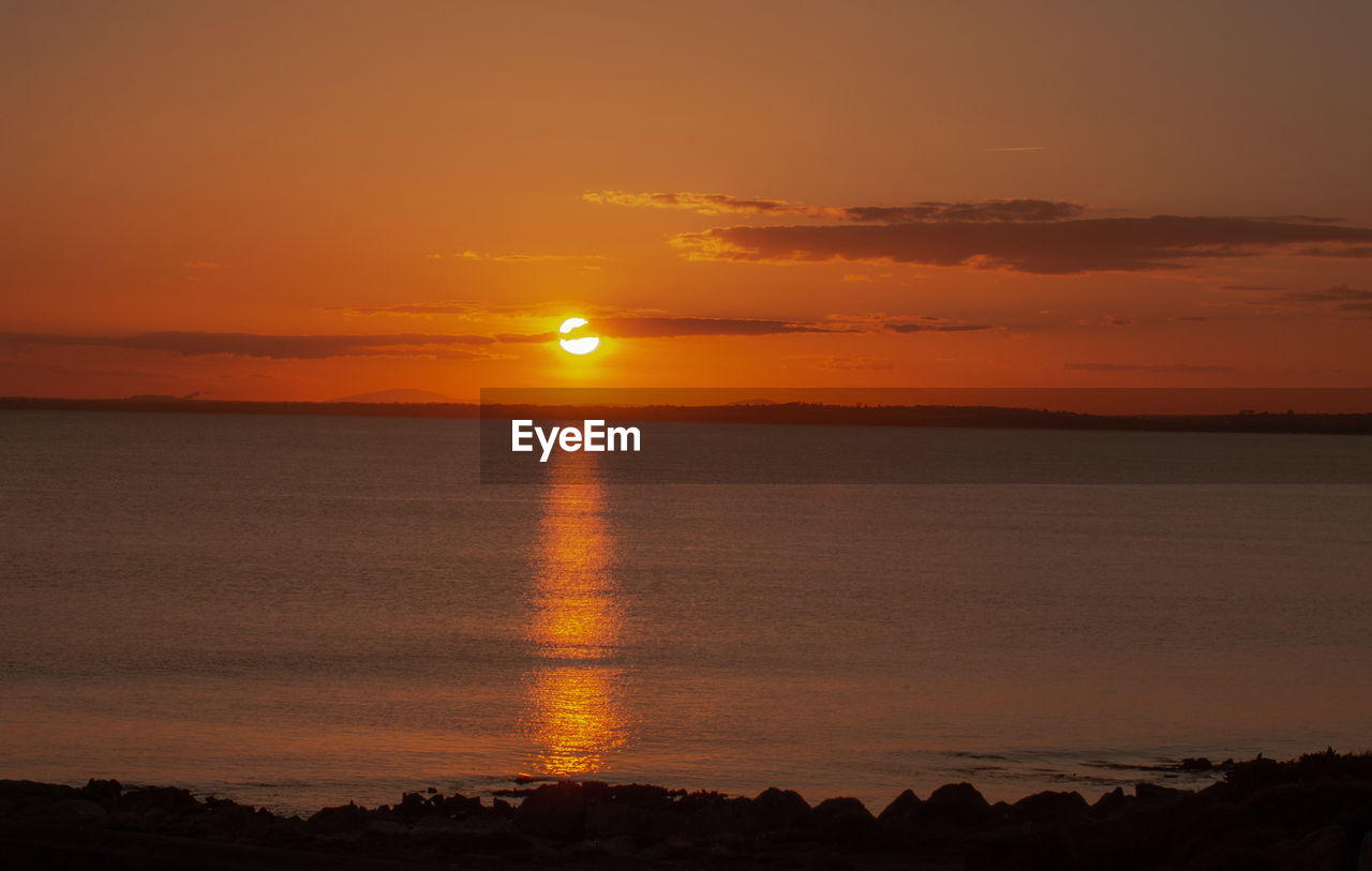 Scenic view of sea against romantic sky at sunset