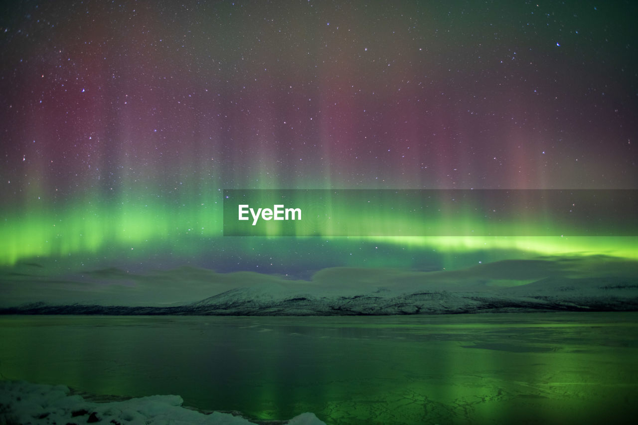 Scenic view of lake and aurora against sky at night