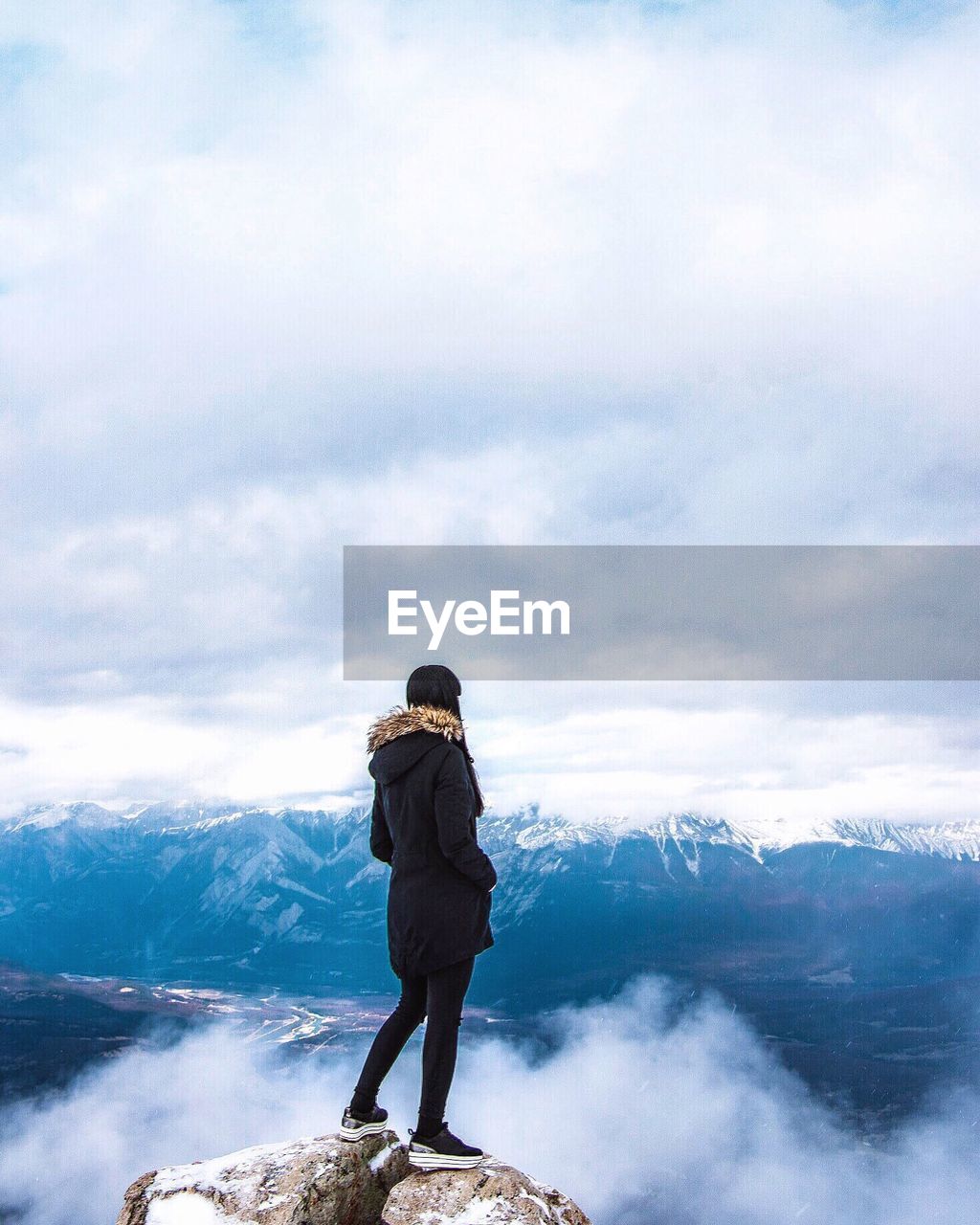 FULL LENGTH REAR VIEW OF MAN STANDING ON MOUNTAIN AGAINST SKY