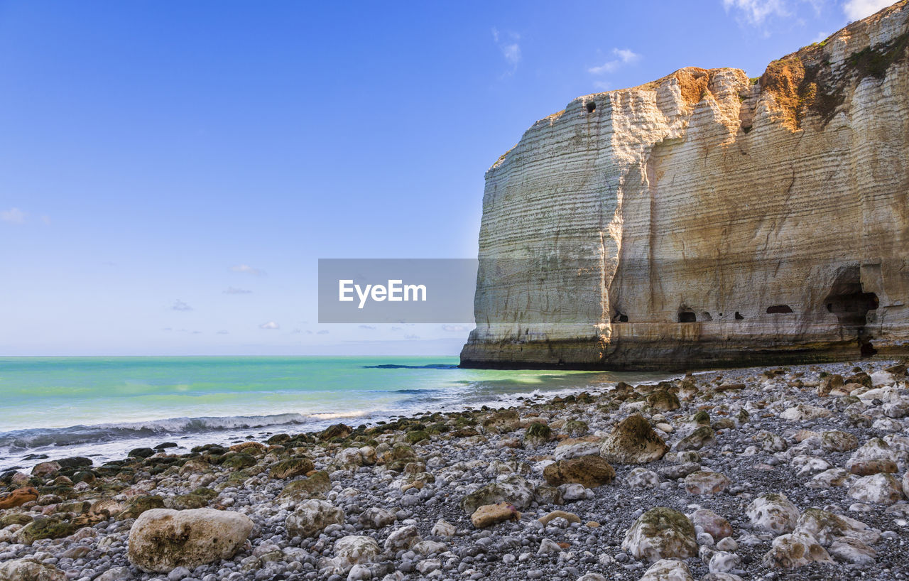 SCENIC VIEW OF ROCK FORMATIONS ON BEACH AGAINST SKY