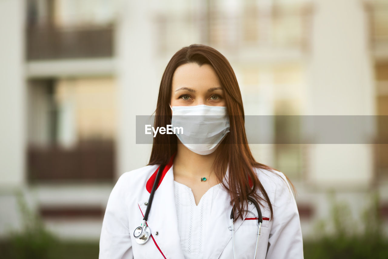 Portrait of doctor wearing mask standing outdoors