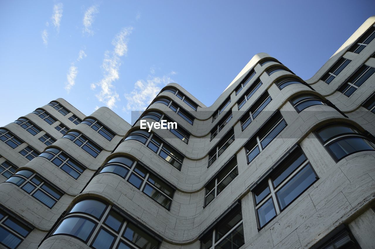 Low angle view of tall building against blue sky