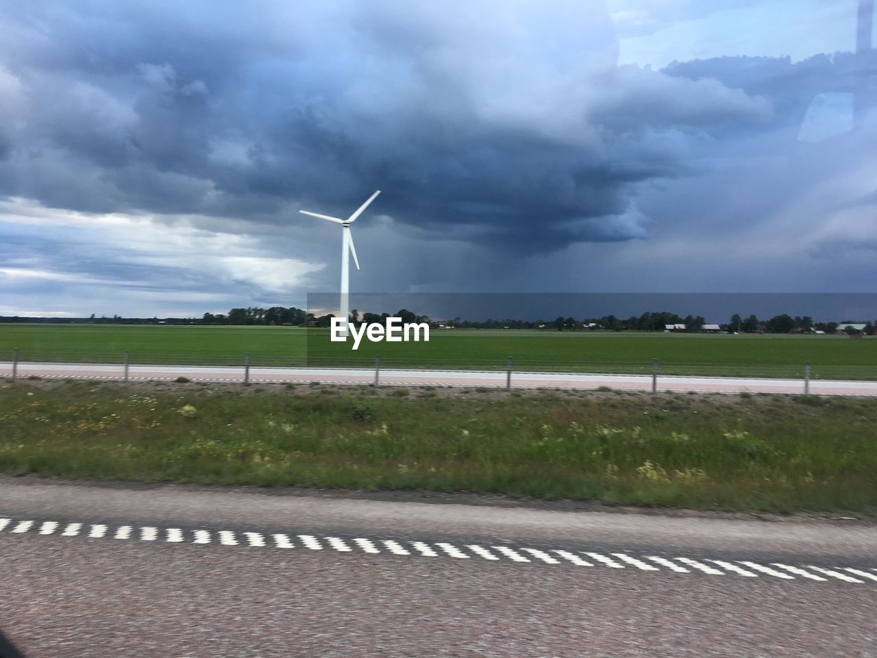 WIND TURBINES IN FIELD AGAINST SKY