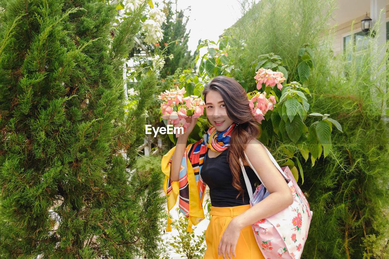 Full length of woman standing by plants