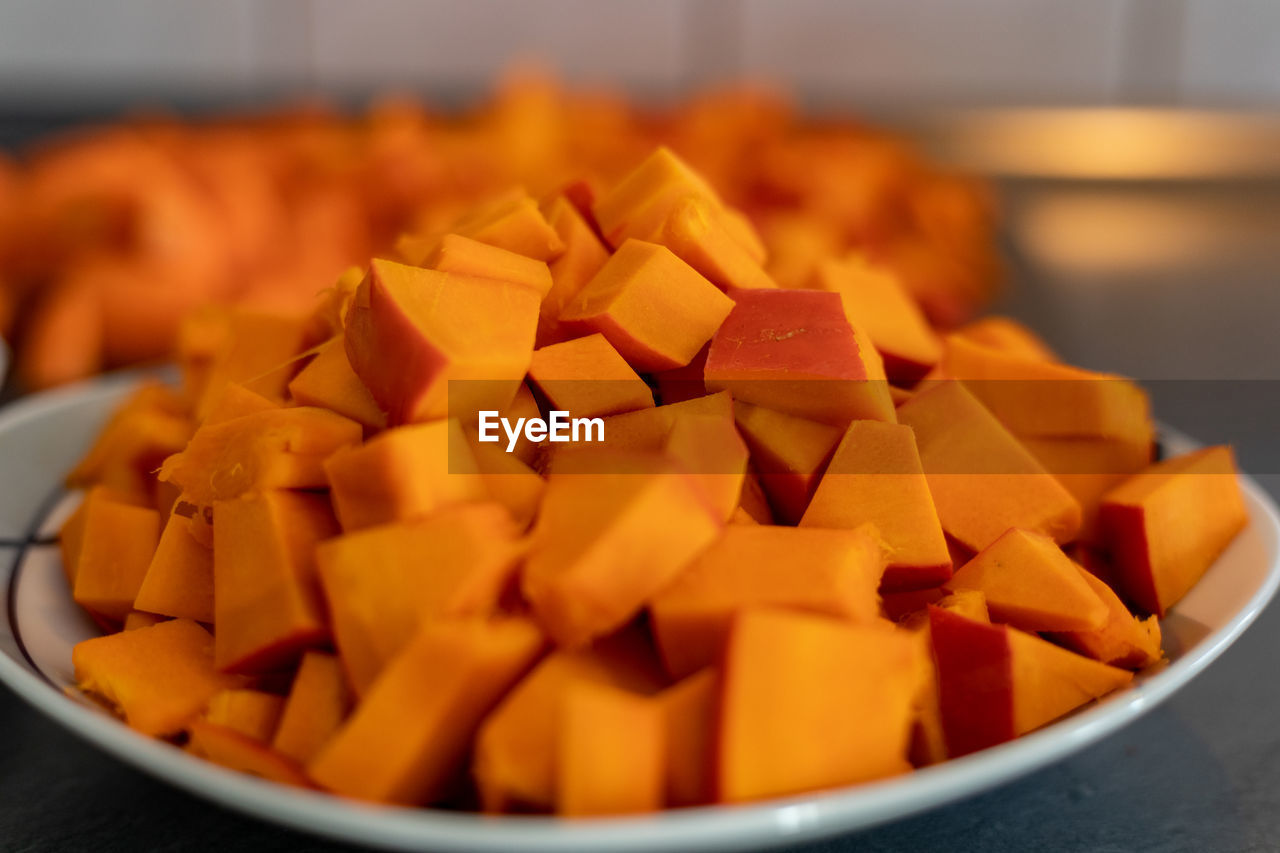 food and drink, pumpkin, food, vegetable, produce, dish, carrot, healthy eating, freshness, indoors, chopped, wellbeing, large group of objects, no people, bowl, orange color, close-up, mango, selective focus, focus on foreground, abundance, kitchen