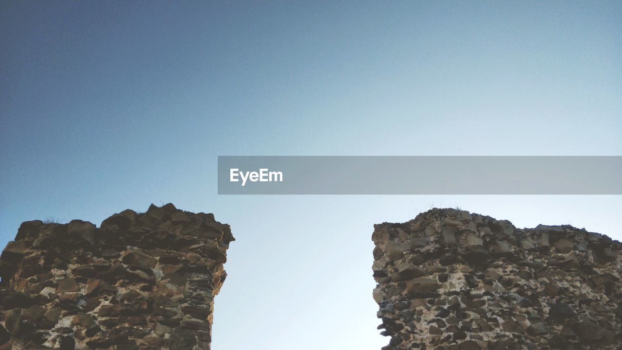 LOW ANGLE VIEW OF ROCK FORMATIONS AGAINST SKY