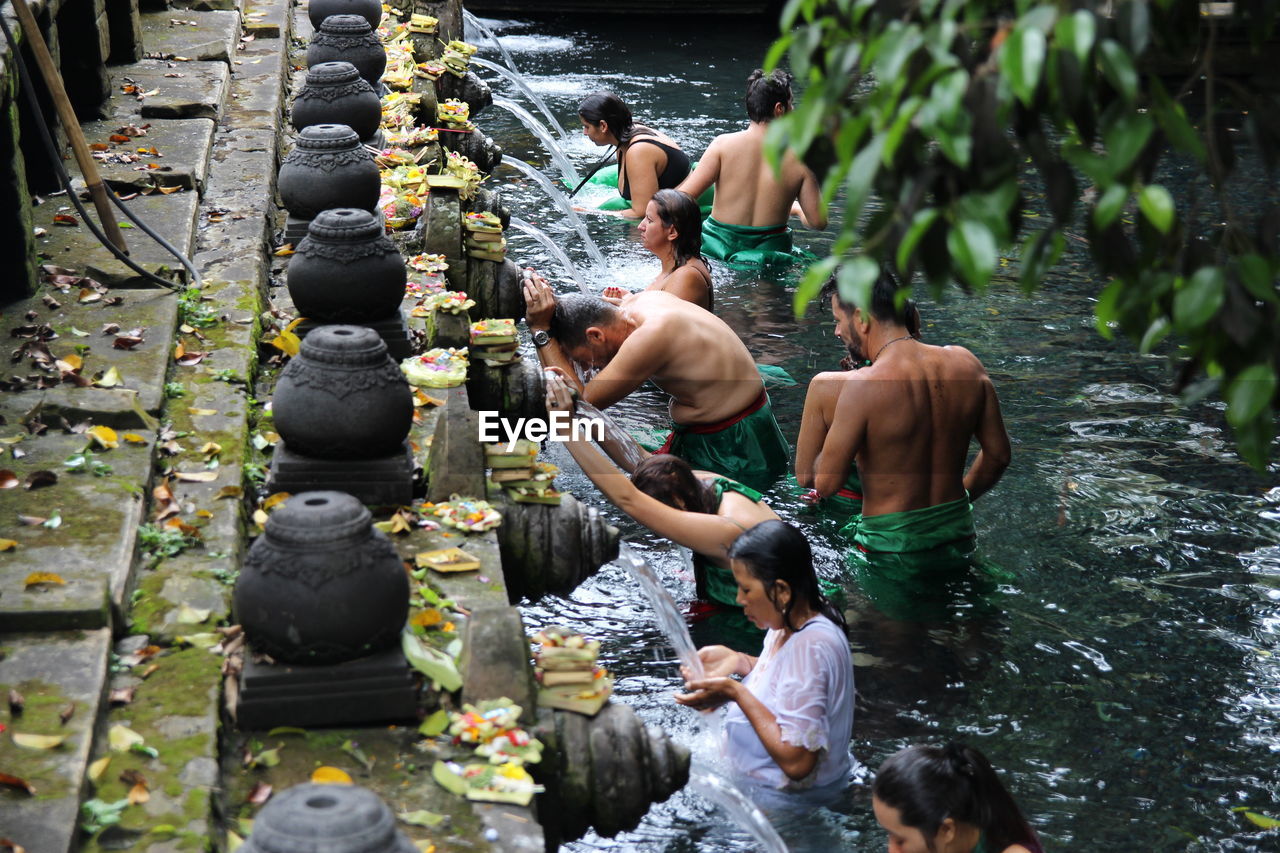 People waiting for bath in fountain at temple