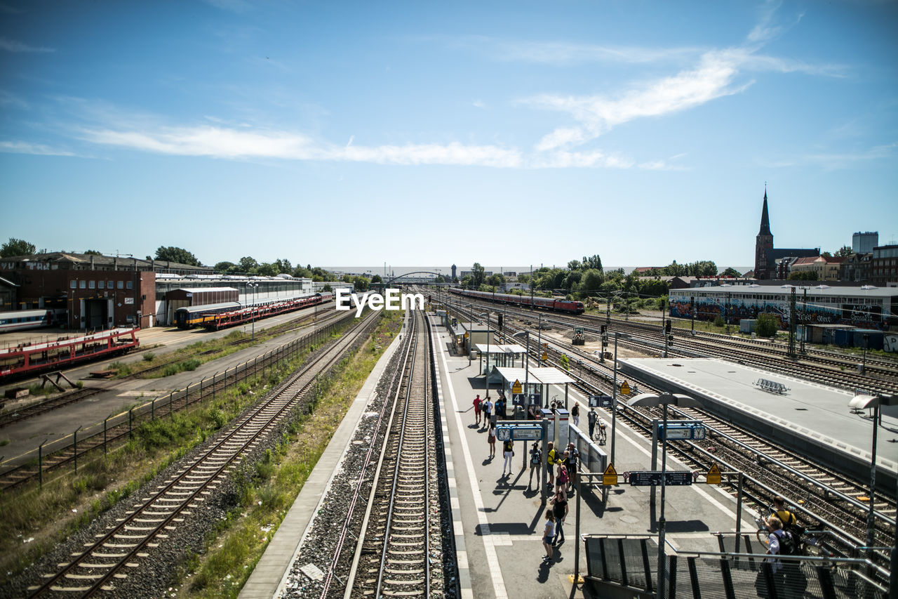 HIGH ANGLE VIEW OF TRAIN AT RAILROAD STATION AGAINST SKY