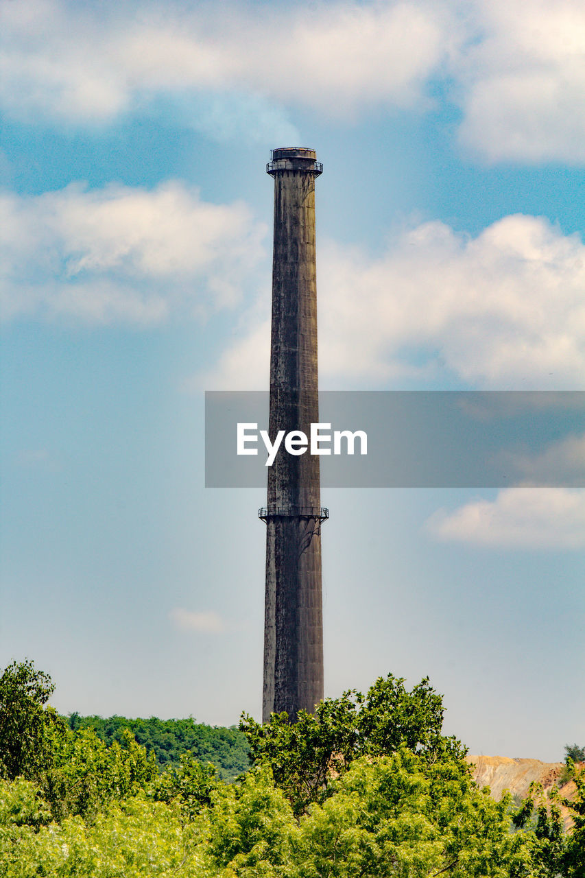 Low angle view of industrial chimney against sky