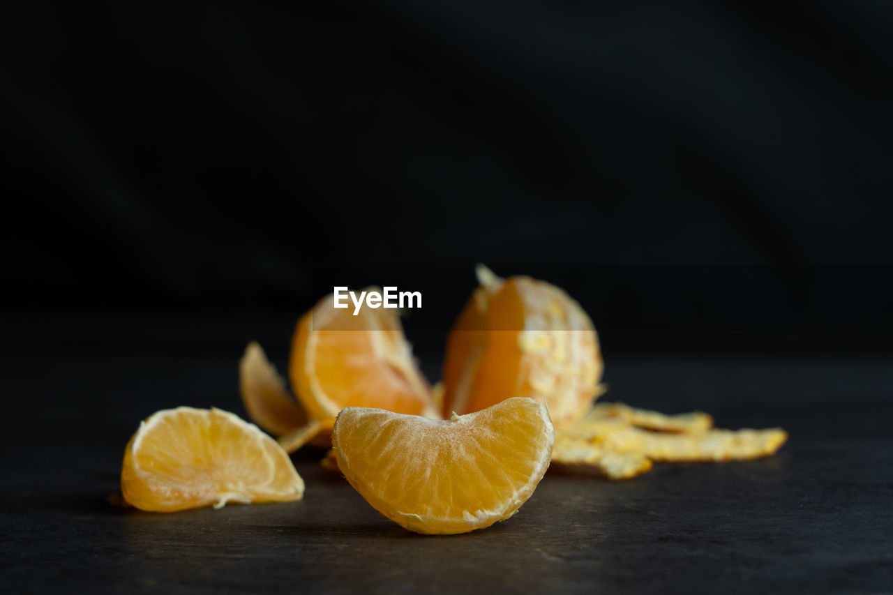 A peeled tangerine on black background