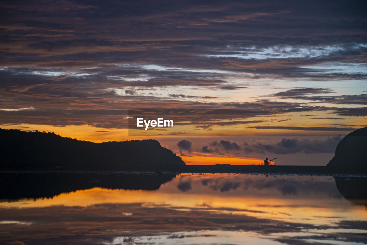 scenic view of sea against dramatic sky during sunset