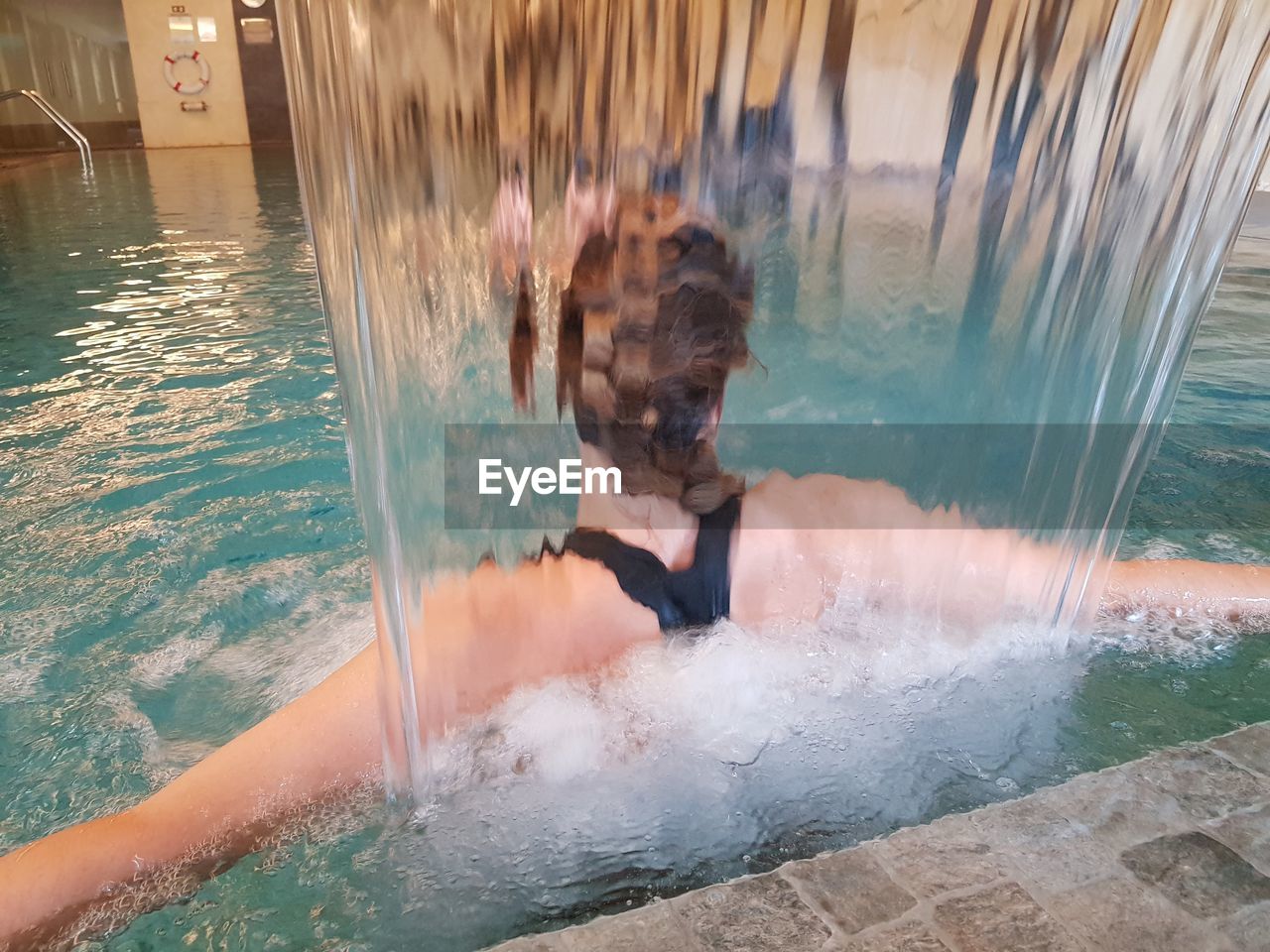 REFLECTION OF MAN SWIMMING IN POOL