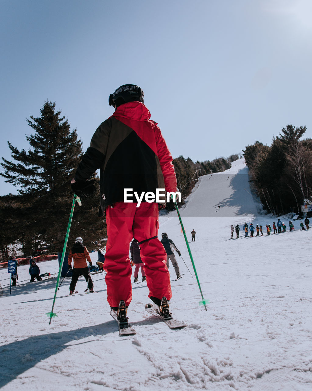 Rear view of person skiing on snow covered field against sky