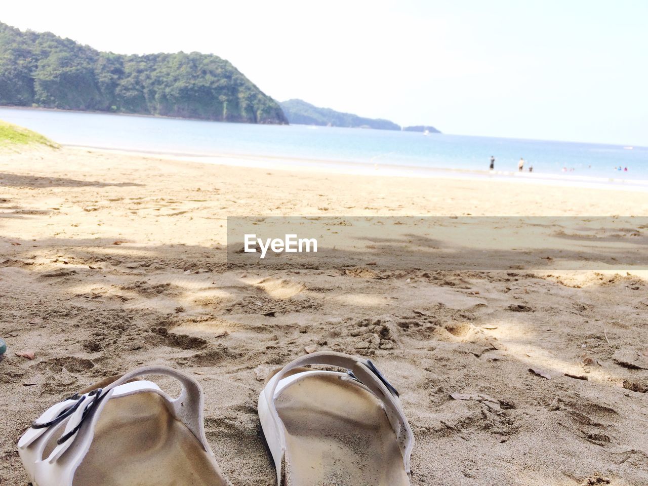 LOW SECTION OF WOMAN STANDING ON BEACH